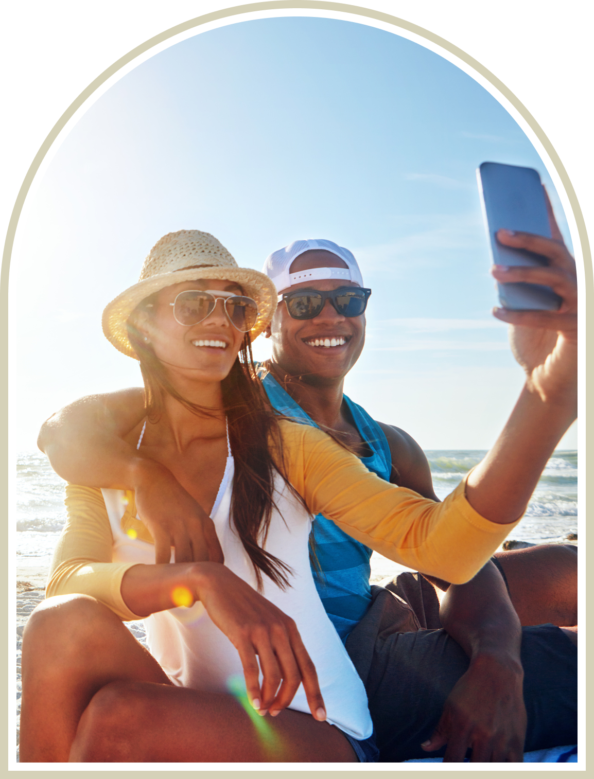 Couple taking a sunny selfie outdoors with smiles and sunglasses.
