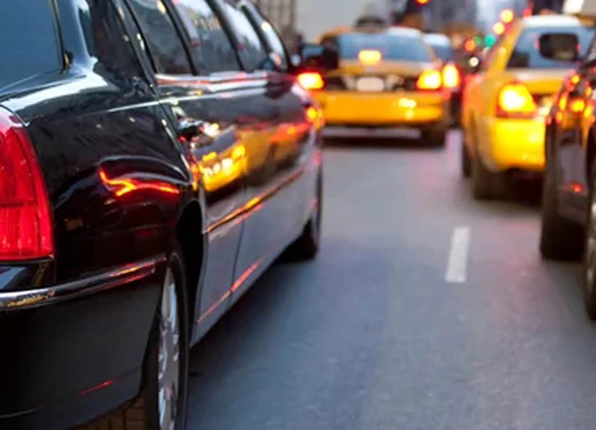 Cars lined up in slow traffic on a city street.