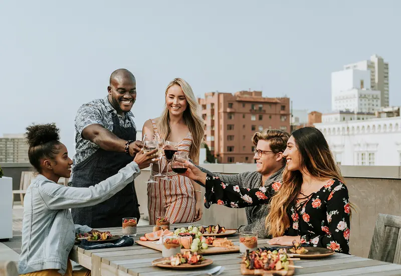 Friends toasting and enjoying an outdoor meal together.