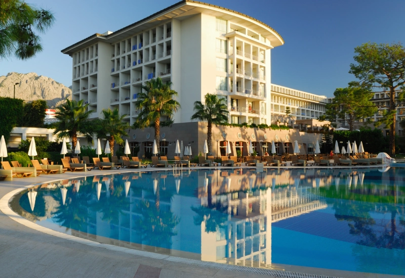 Luxurious resort hotel with a large pool and palm trees.