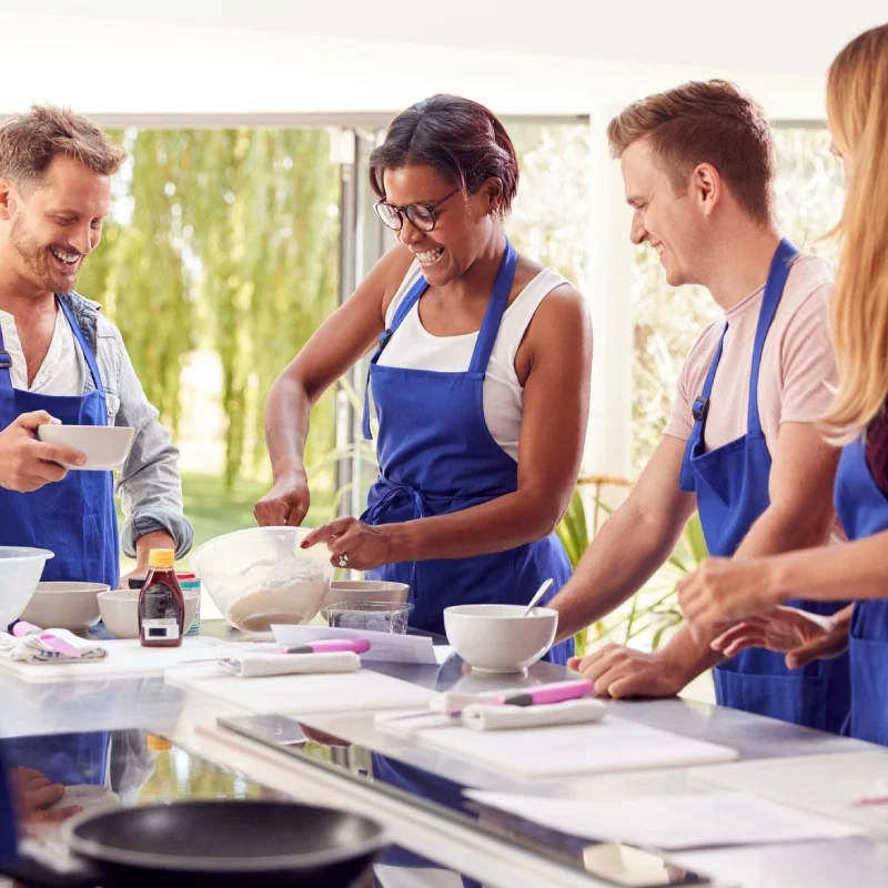 A diverse group cooking together in a bright kitchen.